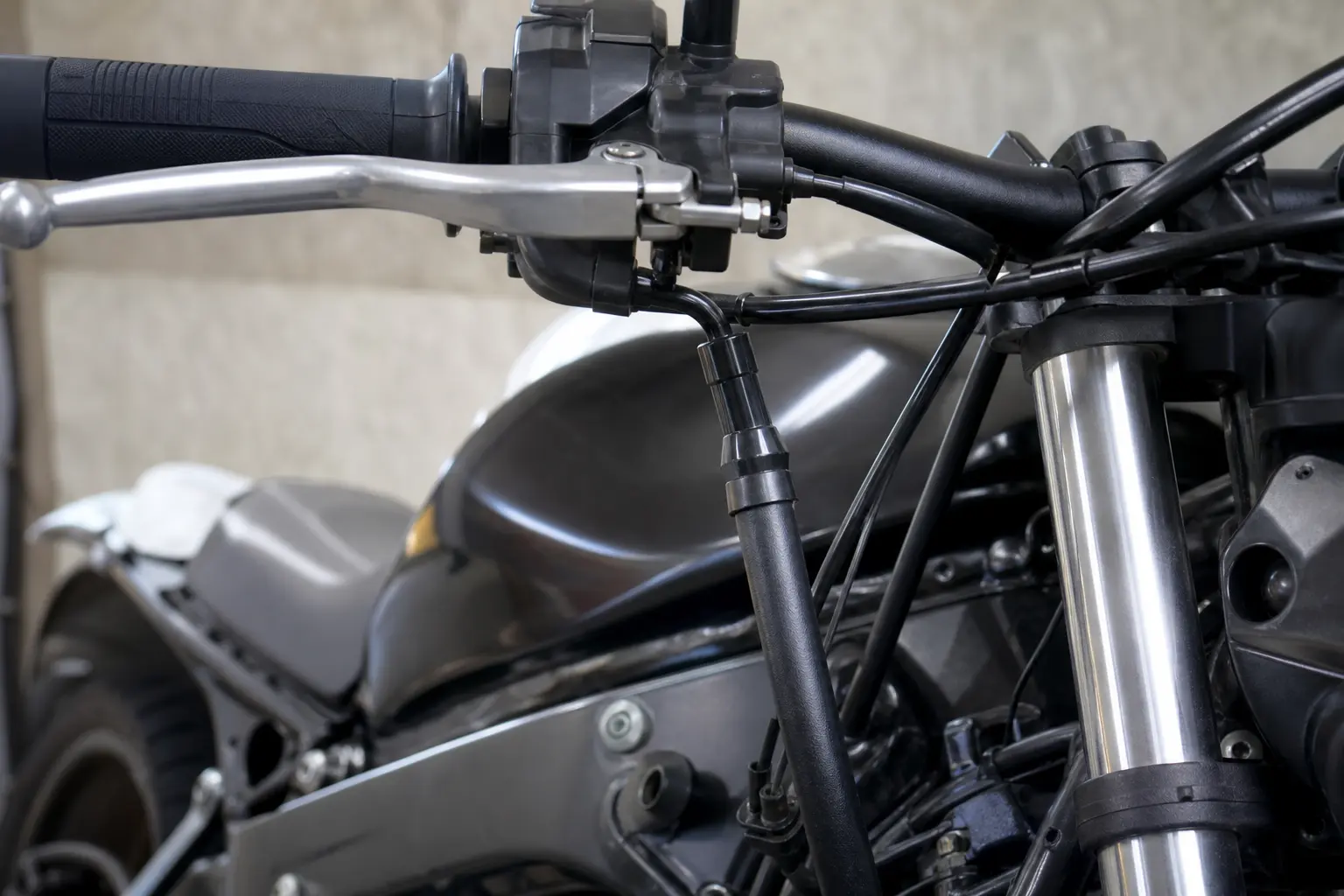 Motorcycle clutch cable routed near the steering head.