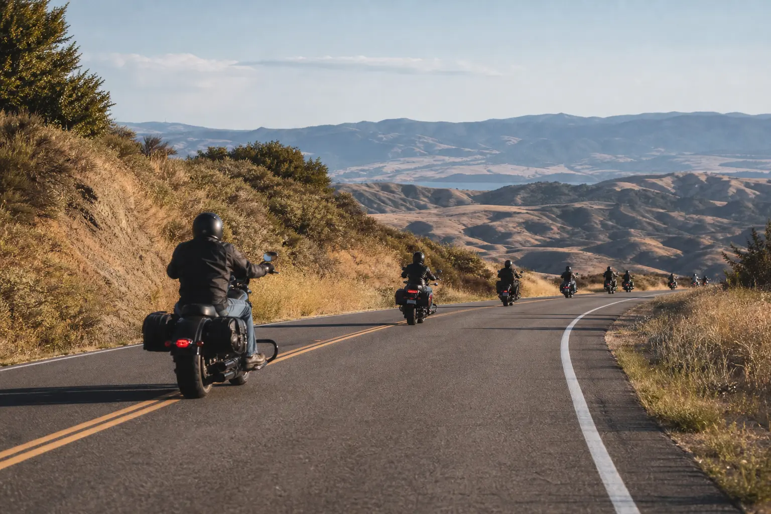 Motorcycle group using single-file spacing through a gentle curve.
