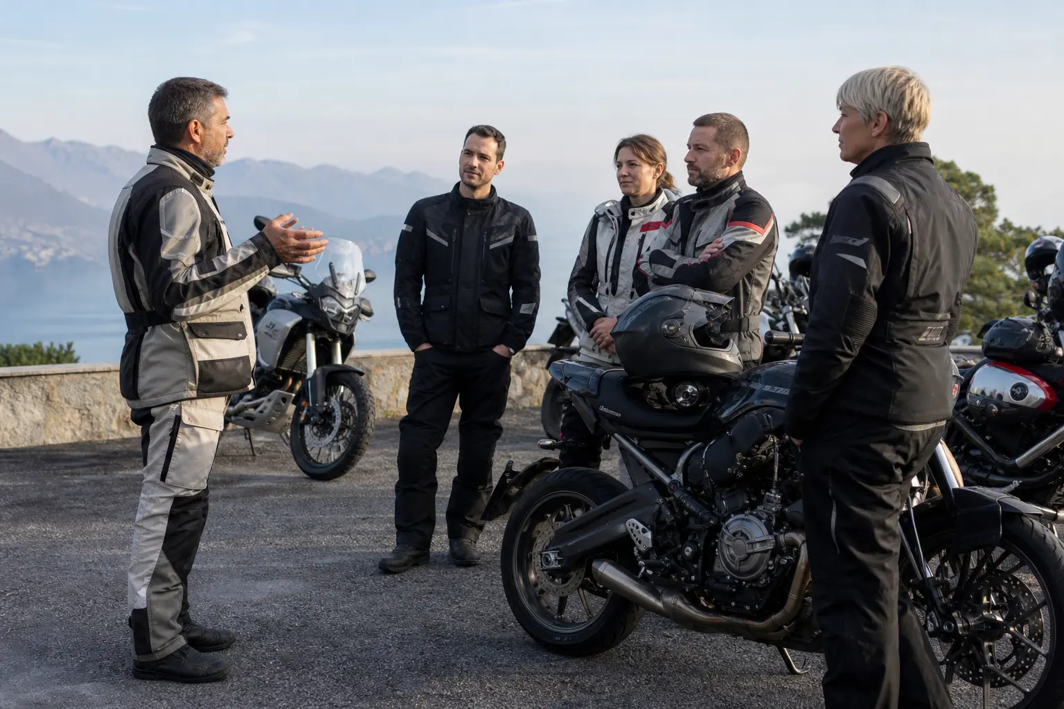 Motorcyclists holding a pre-ride briefing at a roadside stop.